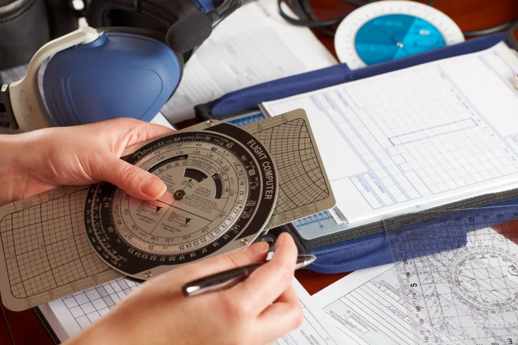 Student pilot using an E6B flight computer for navigation calculations during Canadian Private Pilot Licence exam preparation.